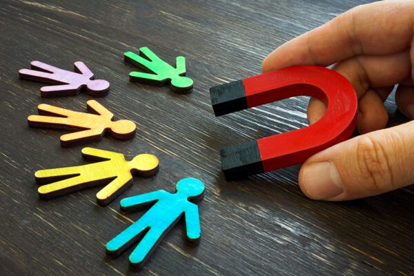 Retention marketing concept. The manager holds a magnet for customers.